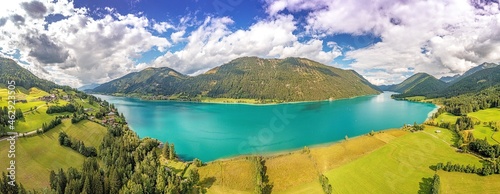 Drone panorama over turquoise lake Weissensee in Austrian province of Carinthia during daytime