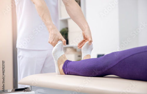 Closeup Doctor osteopath performs sports massage for legs muscle therapy for athlete woman after workout