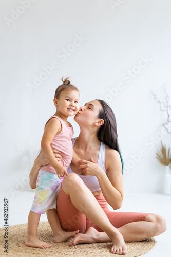 Mother kisses and hugs her Little daughter. Love for children. Children's sports activity. photo