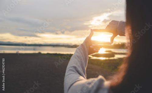 Close up of woman hands making frame gesture with sunset on sky, Female capturing the sunrise, sunlight outdoor,Future planning,