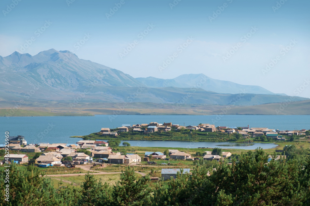 View of a village located on peninsula at the lake with mountains background