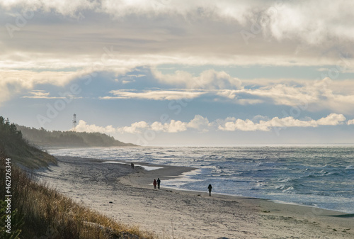 Fototapeta Naklejka Na Ścianę i Meble -  People walking on the beach coastline of Palanga on a stormy day