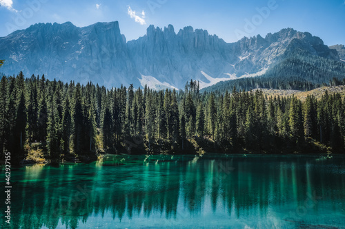 wonderful mountain scenery of the turquoise water of the moraine Carezza Lake lake and silhouette of Latemar mountain group peaks in the background.Dolomites, Italy