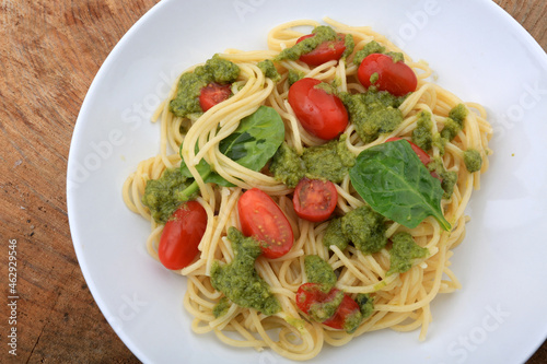 spaguetti pesto sauce with cherry tomatoes and basil