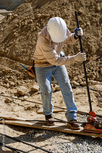 Construction worker using a rebar bender photo
