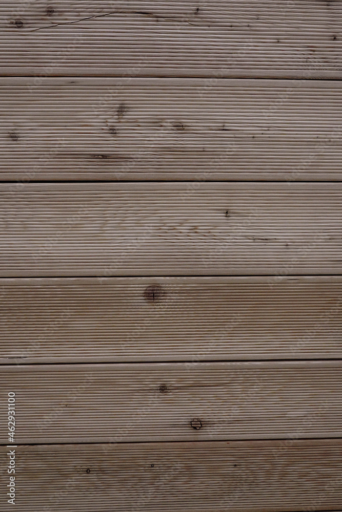 Vertical close-up photo of a brown wooden wall made of boards Vertical close-up photo of a brown wooden wall made of boards