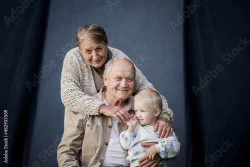 great grandmother and great grandfather with great grandson on blue background
