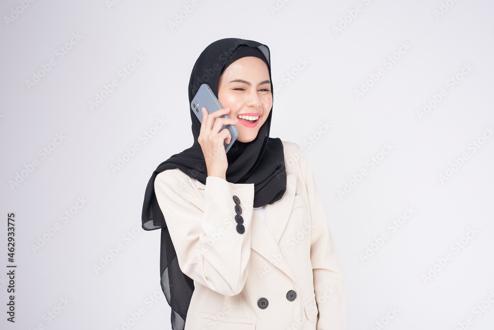 Portrait of young beautiful muslim woman in suit using smart phone over white background. Portrait of young beautiful muslim woman in suit using smart phone over white background.