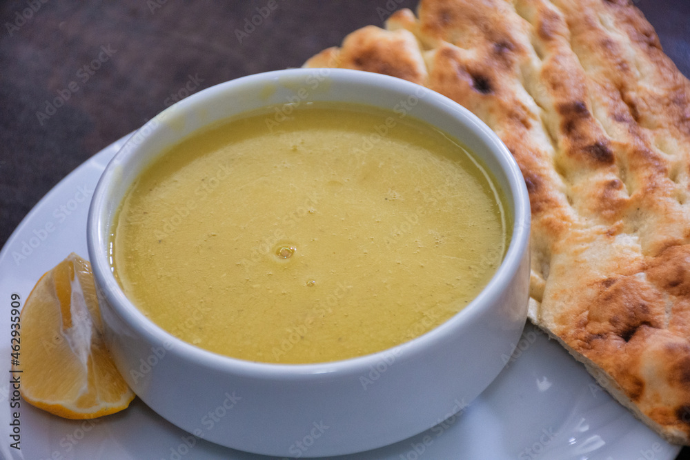 Traditional Turkish lentil soup served with a slice of lemon and tandoori bread near the plate Traditional Turkish lentil soup served with a slice of lemon and tandoori bread near the plate