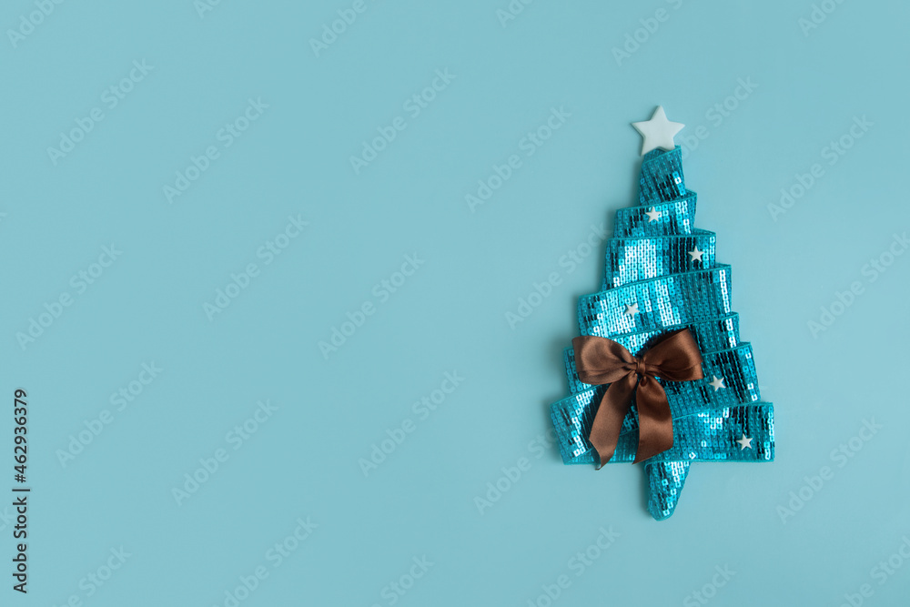 Happy New Year greeting card with flat lay abstract shiny Christmas tree made of ribbon. Copy space