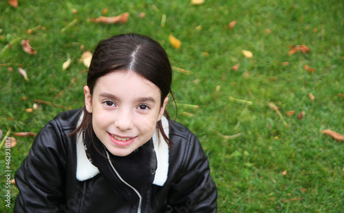 beautiful girl lies on green grass in the park in autumn.