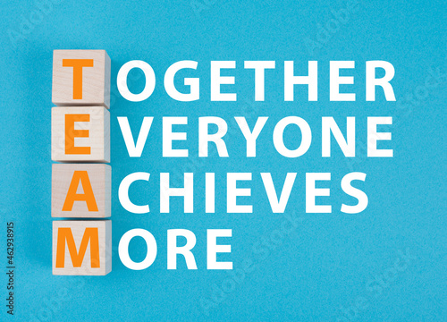 Team, together everyone achieves more is standing on a blue colored background, business strategy and concept photo