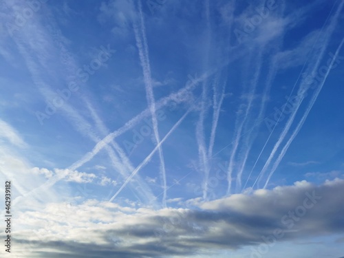 Blauer Himmel überzogen mit Chemtrails der Flugzeuge photo