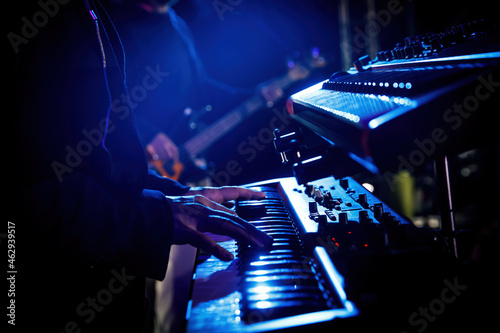Artist playing on the keyboard synthesizer piano keys during the live concert. photo