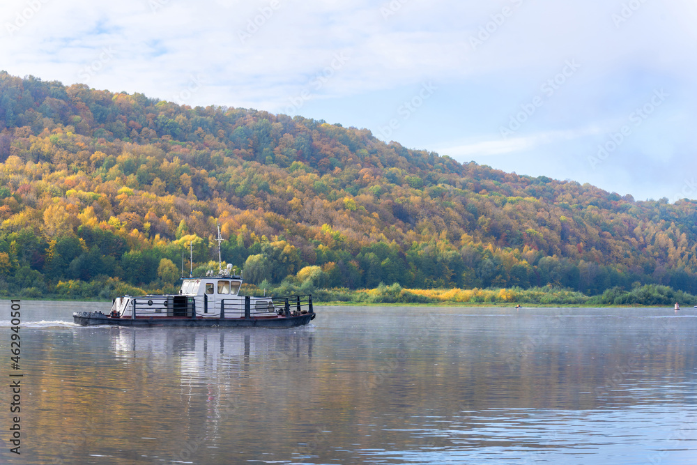 A small tugboat on the autumn river