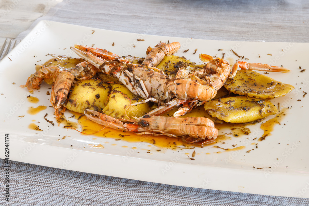 Ravioli stuffed with ricotta and truffle, sautéed with butter, sage and scampi