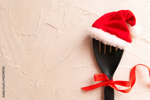 Christmas and new year composition with kitchen tools and Santa hat on grey conctere background. Xmas cooking concept. Top view with copy space photo