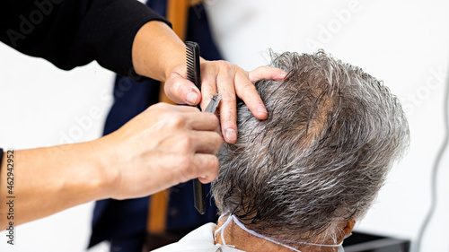 hands of a woman stylist cutting a man's hair