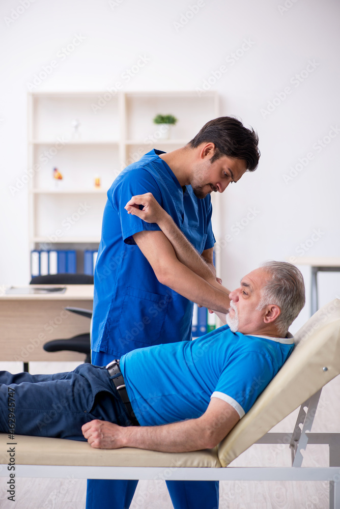 Obraz premium Old male patient visiting young male doctor