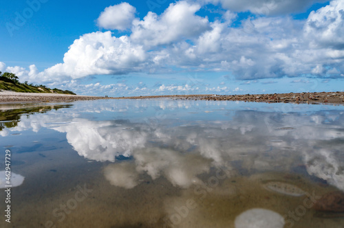 Reflection of clouds in the water. Beautiful sky. The sea coast. Deserted seashore.
