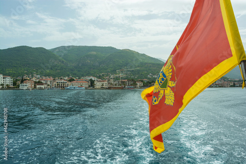 Montenegro flag and view of Budva from the sea