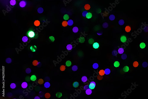 Bokeh blue background. Bright festive multicolored circles and lines in motion. Defocused abstract colorful lights 