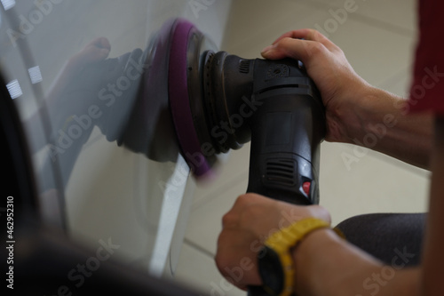 Wall Mural Master polishes car body from scuffs and scratches closeup