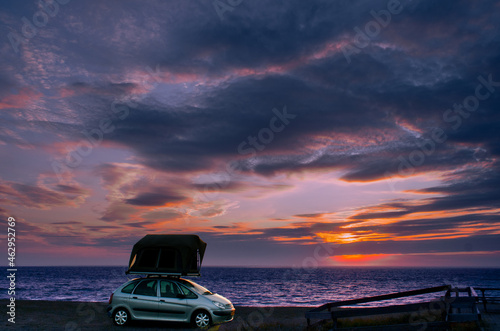 Car with tent watch sunset