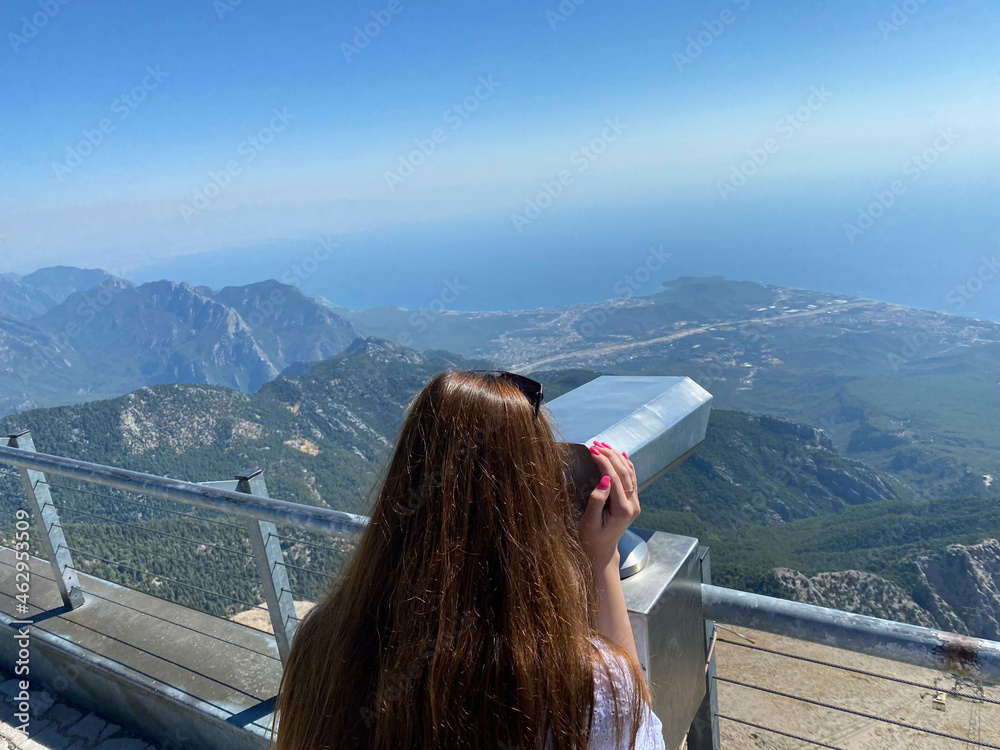Person having a look through the tourist binoculars at Georgian mountains