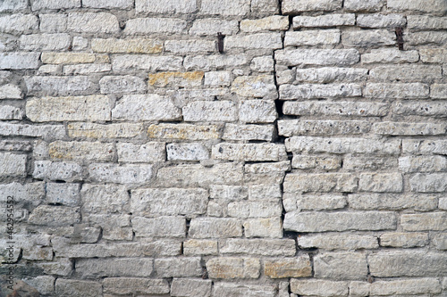 crack in the brick wall of white gray brick