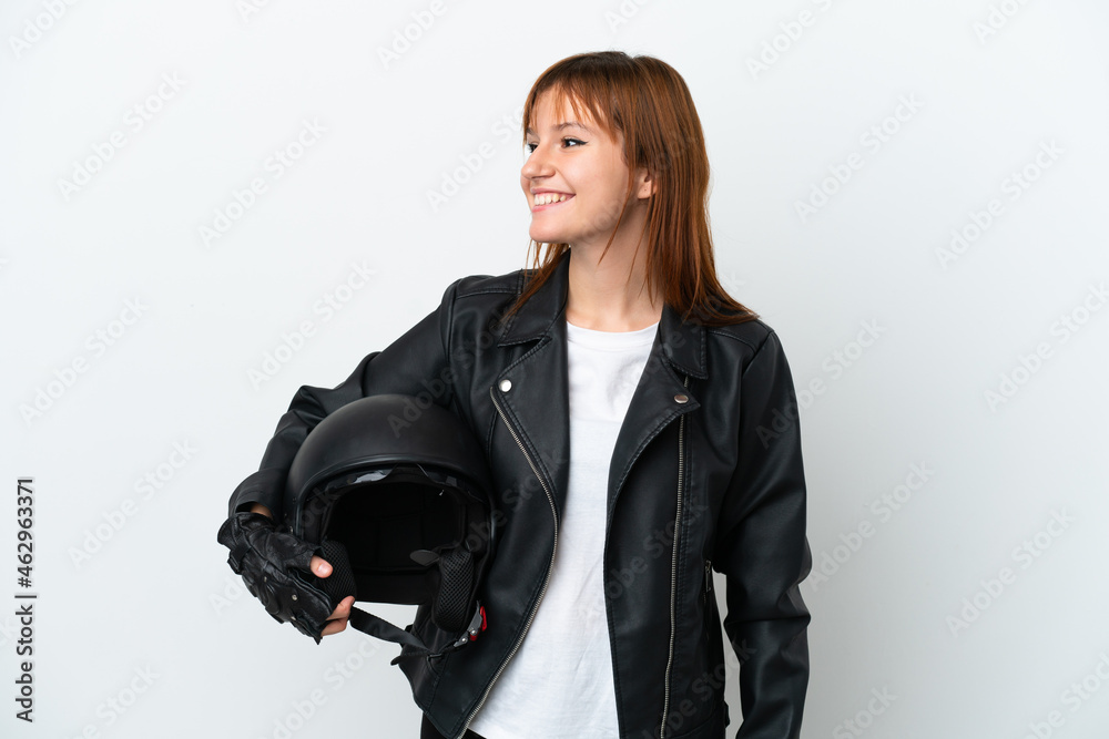 Redhead girl with a motorcycle helmet isolated on white background looking side Redhead girl with a motorcycle helmet isolated on white background looking side