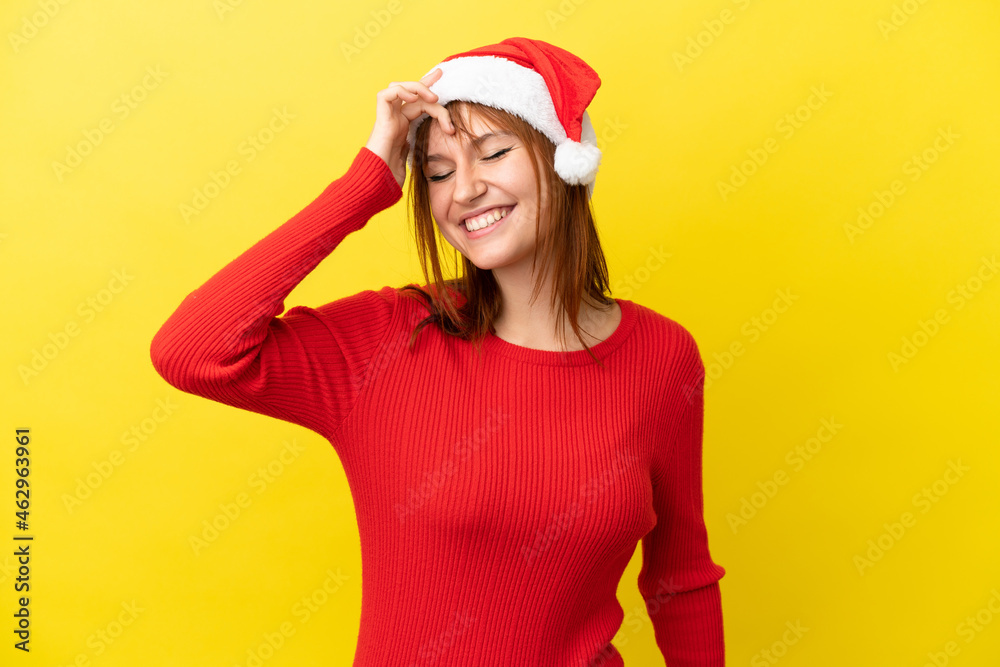 Redhead girl with christmas hat isolated on yellow background laughing Redhead girl with christmas hat isolated on yellow background laughing