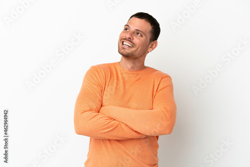 Brazilian man over isolated white background looking up while smiling