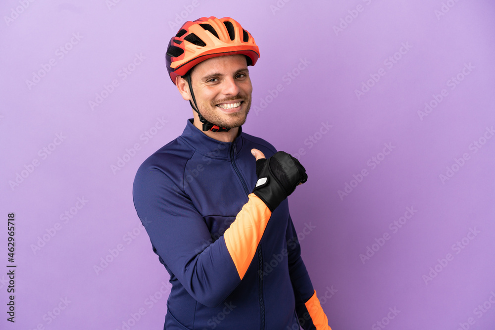 Young Brazilian cyclist man isolated on purple background proud and self-satisfied - obrazy, fototapety, plakaty 