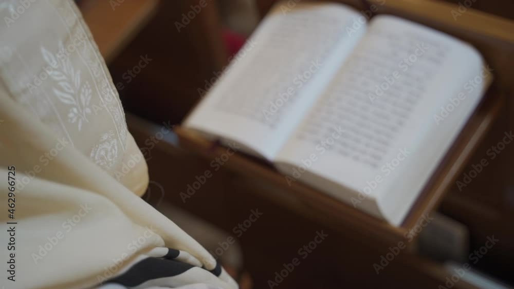 An old man, a Jew praying, reading a book. Close-up of a book.