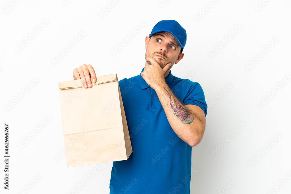 Brazilian taking a bag of takeaway food isolated on white background having doubts Brazilian taking a bag of takeaway food isolated on white background having doubts