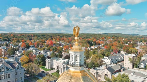 Circling Eagle Atop Dome of New Hampshire Capitol Building. Fall Foliage in Background photo