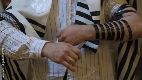 An adult male, a Jew, puts on tefillin photo