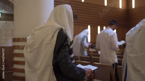 A group of people, Jews, pray in the synagogue. Rearview. photo