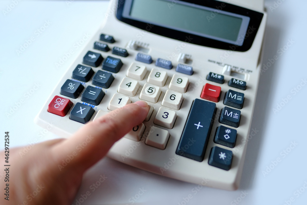 closeup keys and display of the calculator, female hand presses the buttons of the stationary Cash Register, counts and calculates counting operations, small family business concept closeup keys and display of the calculator, female hand presses the buttons of the stationary Cash Register, counts and calculates counting operations, small family business concept
