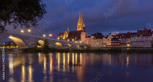 Regensburg. Old stone bridge over the Danube river in the night light.