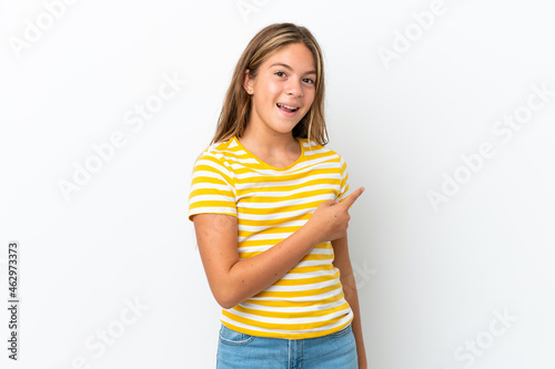 Little caucasian girl isolated on white background surprised and pointing side