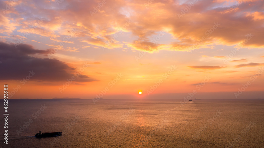 Photograph Of Seascape Aerial View at Twilight And Small Container Ship Sailing In Sea Pink Sky And The Sunset Background.