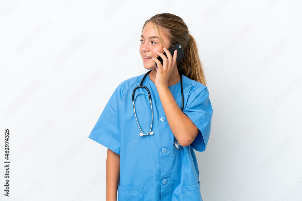 Little caucasian girl disguised as surgeon isolated on white background keeping a conversation with the mobile phone with someone Little caucasian girl disguised as surgeon isolated on white background keeping a conversation with the mobile phone with someone