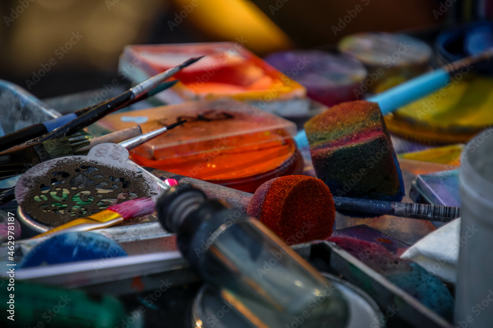 Fototapeta premium Tools and supplies for face painting on a table, creative mess