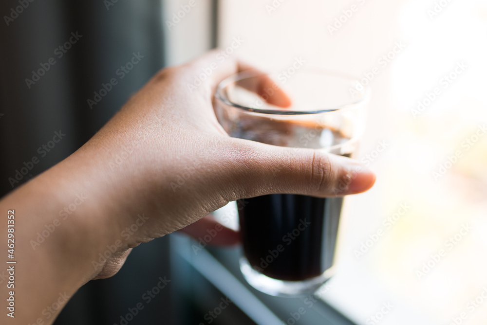 Mulher segurando um copo americano (copo lagoinha) com café