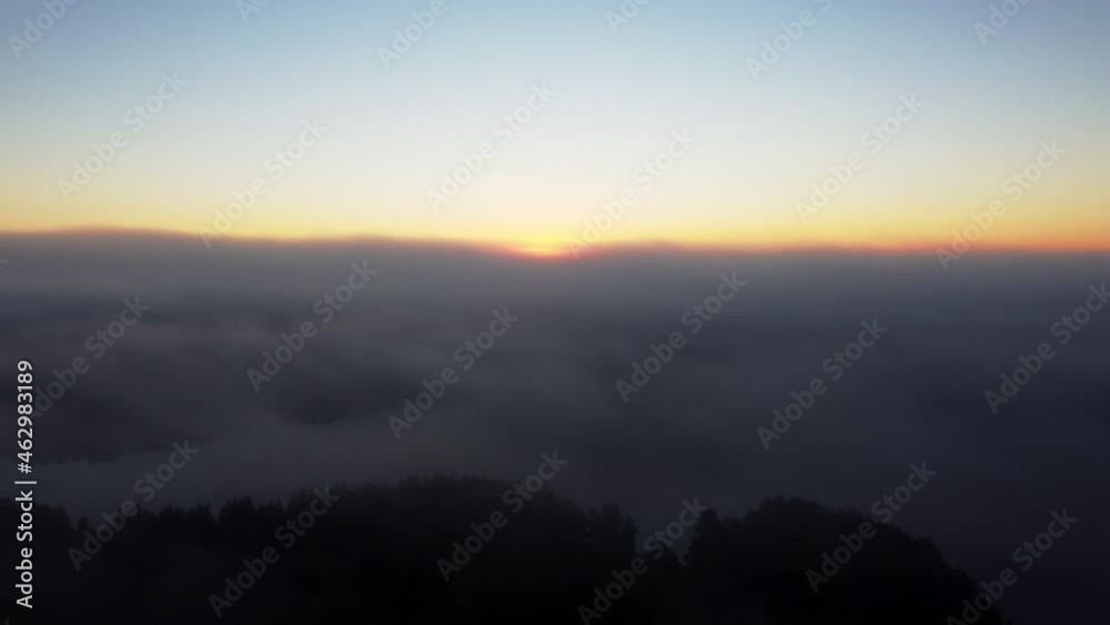 Aerial backwards shot showing mystic cloudscape during sunset in background - High angle drone flight above clouds - Cinematic nature footage Aerial backwards shot showing mystic cloudscape during sunset in background - High angle drone flight above clouds - Cinematic nature footage
