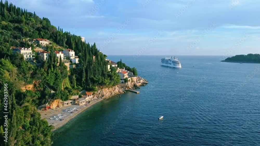 Aerial shot of a beach on the coast of Croatia with a cruise ship at sea, Europe Aerial shot of a beach on the coast of Croatia with a cruise ship at sea, Europe