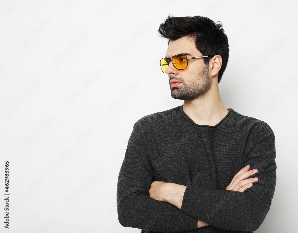 Obraz premium Elegant young handsome man in smart casual wear and sunglasses.