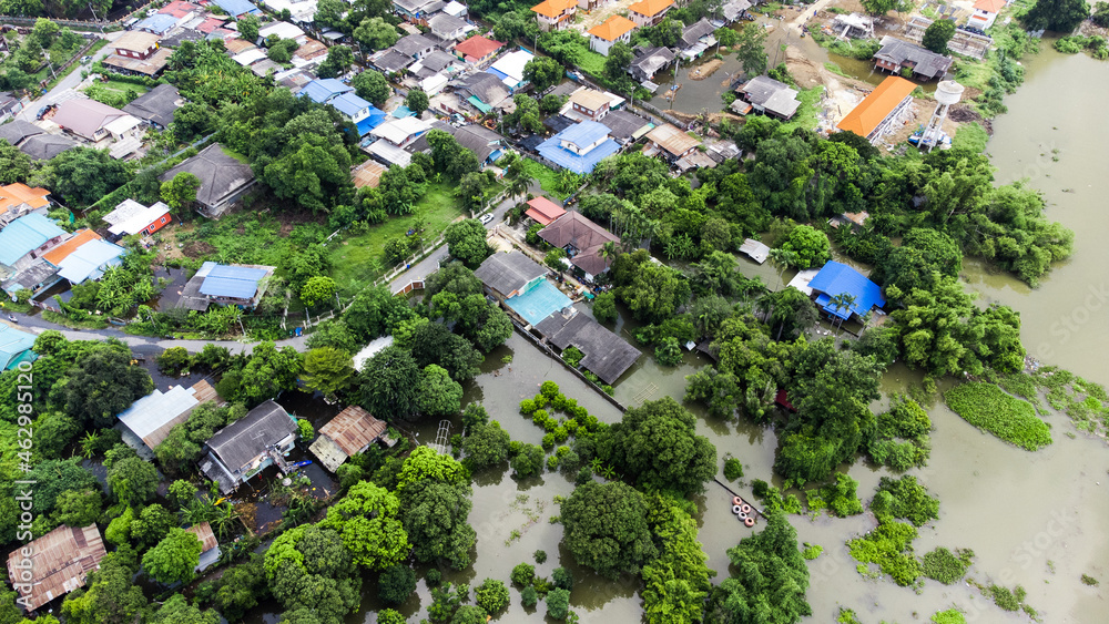 Flood waters overtake a house and rice field at Central of Thailand in 2021. Many buildings are submerged in water. Photo disaster from above view by drone Flood waters overtake a house and rice field at Central of Thailand in 2021. Many buildings are submerged in water. Photo disaster from above view by drone
